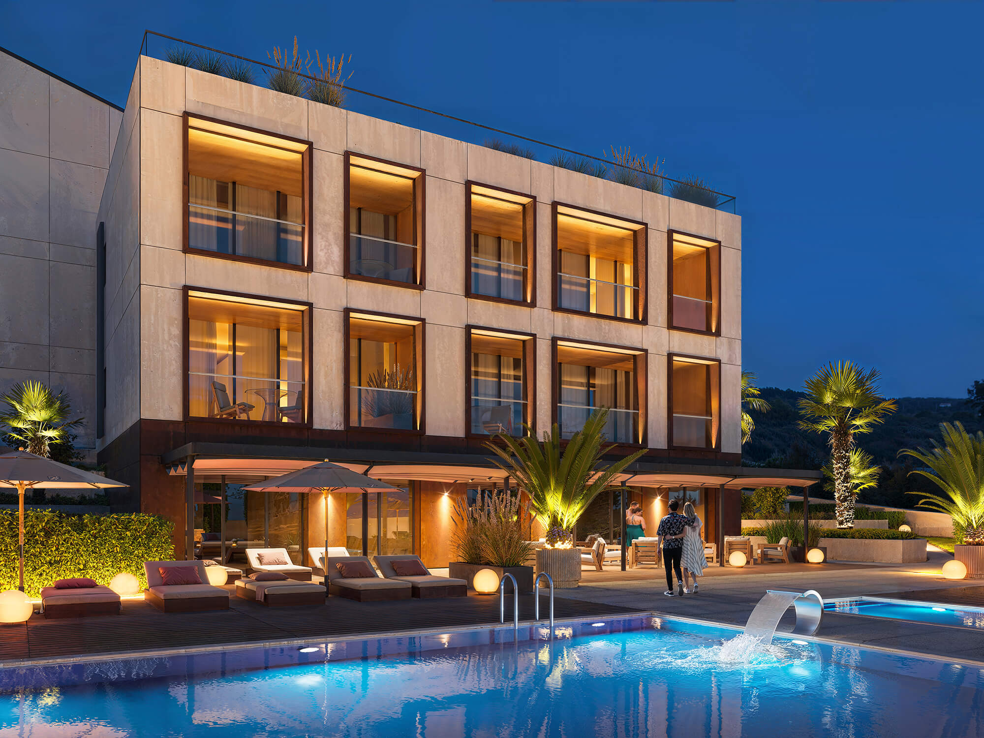 Strefa basenowa przy hotelu wieczorem.