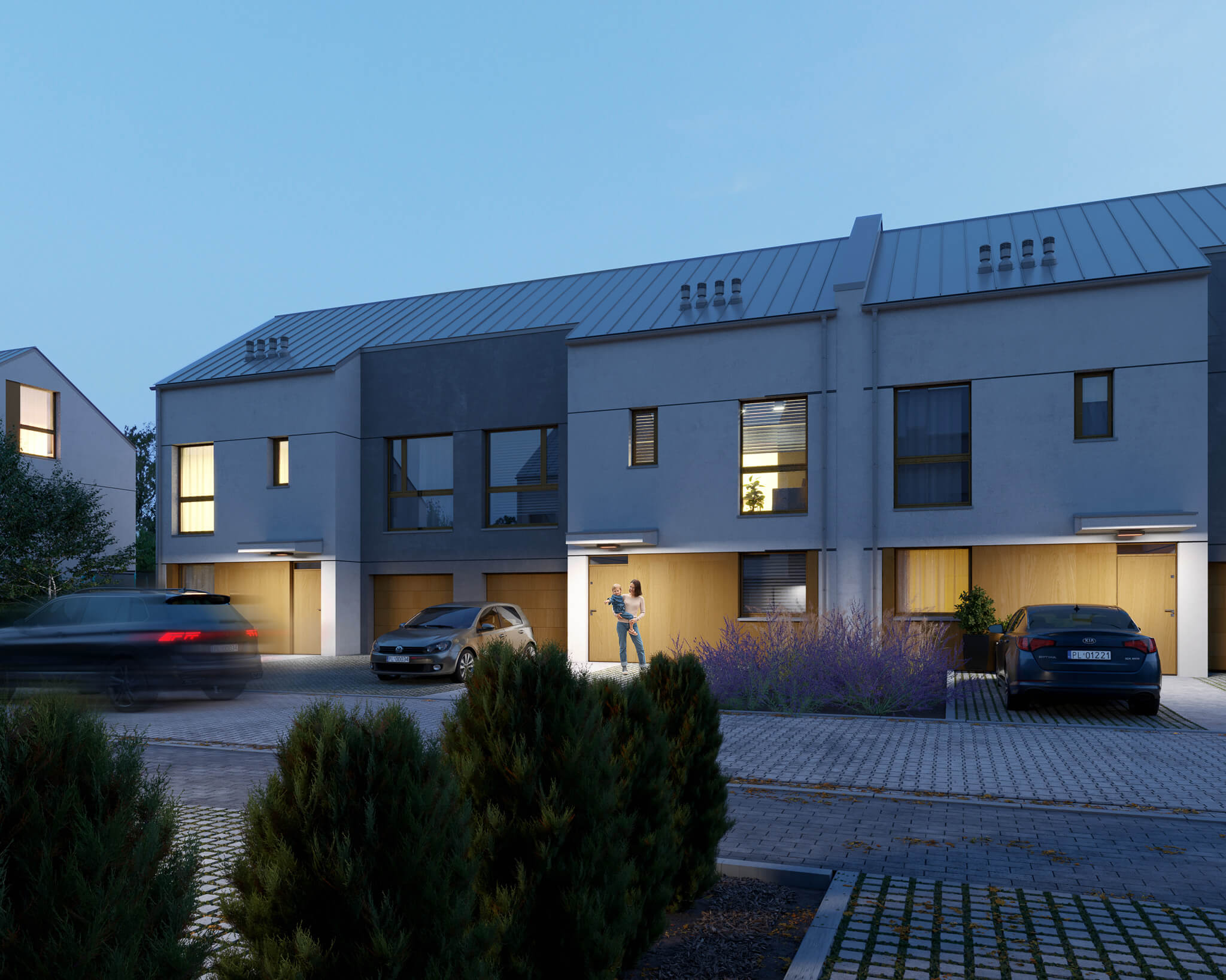 Podjazd do budynku szeregowego z parkingami i podświetlaną elewacją, wieczorem.