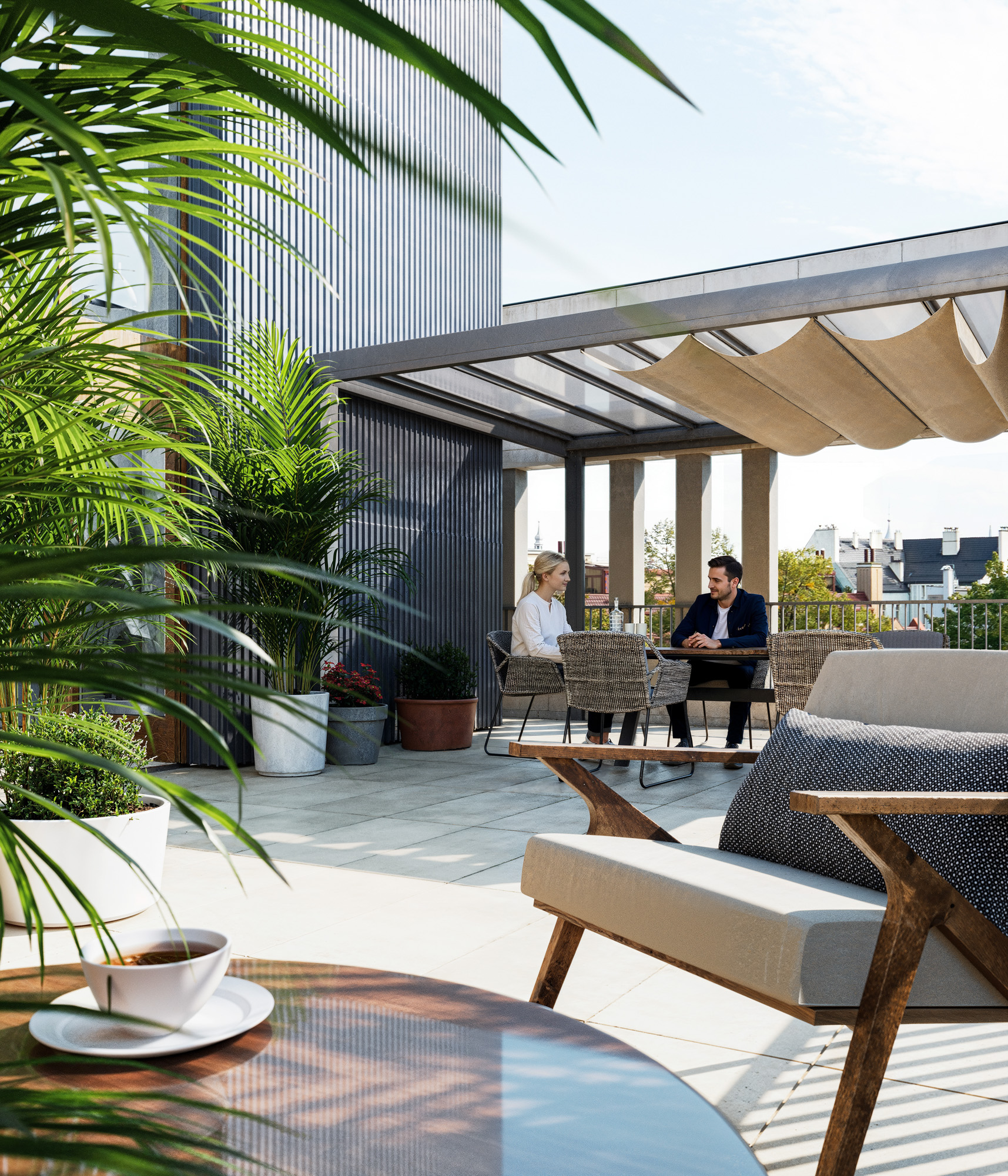 Taras na budynku wielorodzinnym z materiałowym zadaszeniem.