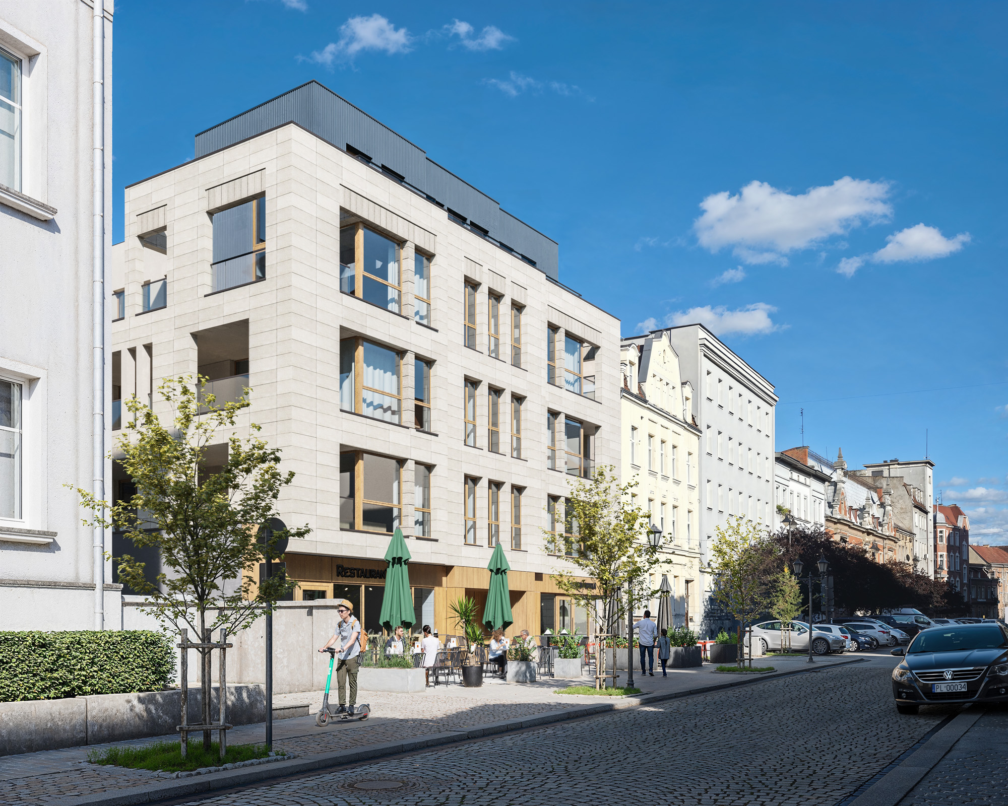 Budynek wielorodzinnym w centrum miasta przy brukowanej ulicy.